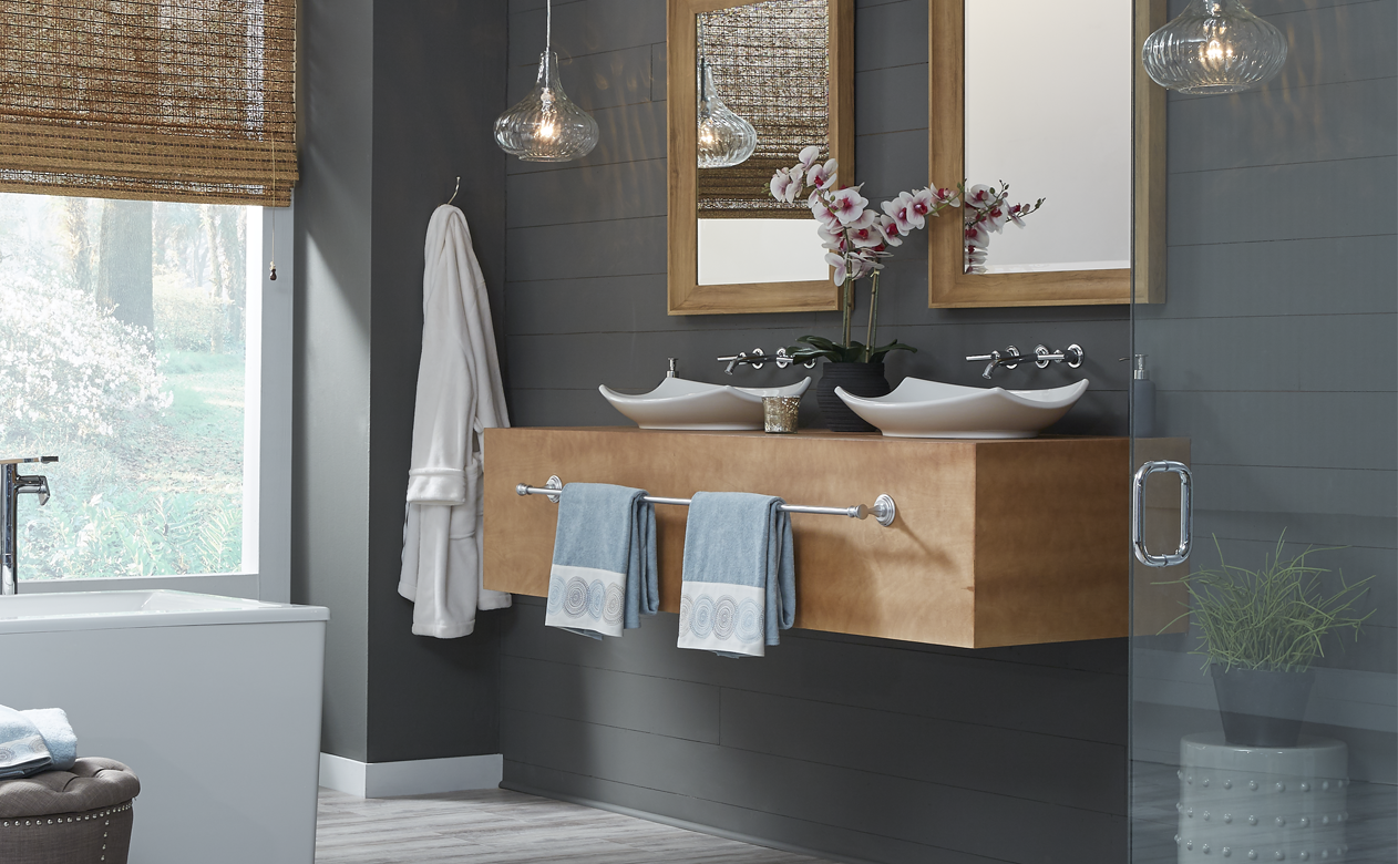 grey-washed wood-look waterproof flooring in dark grey bathroom with glass shower and soaker tub